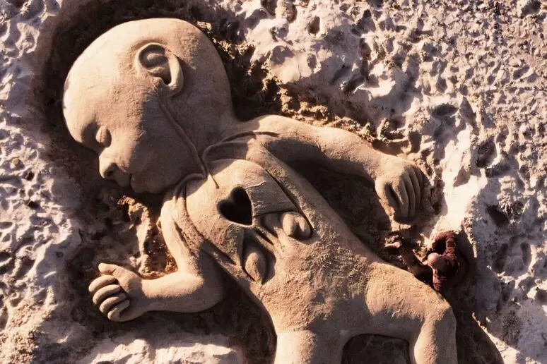 cuoricino domenico Scultura in sabbia sul litorale sardo per il piccolo Domenico. Cuoricino stilizzato in evidenza sul petto